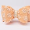 Peach headband with daisy-embroidered bow and faux pearl strand for girls