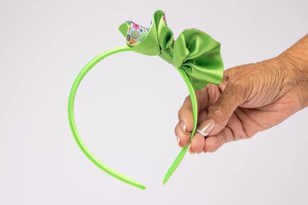 Handmade lime green kids headband showing satin bow detail